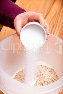 Put sugar from ceramic bowl into a baking bow