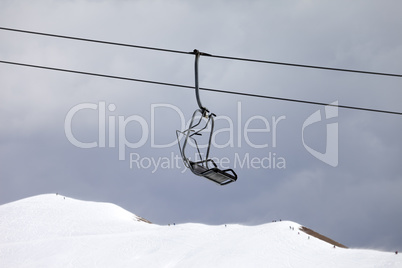 Chair lift and off-piste slope at gray day