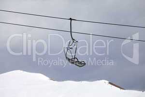 Chair lift and off-piste slope at gray day