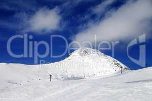 Chair-lift and ski slope at sun wind day