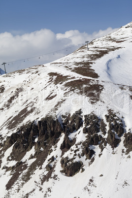 Off-piste slope with stones and chair-lift in little snow year