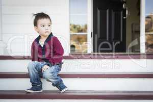 Melancholy Mixed Race Boy Sitting on Front Porch Steps