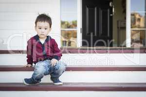 Melancholy Mixed Race Boy Sitting on Front Porch Steps