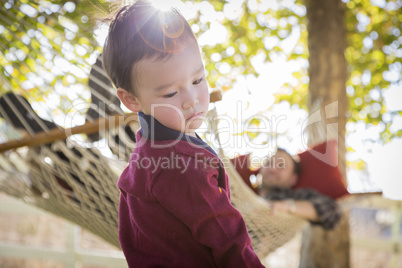 Mixed Race Boy Having Fun While Parent Watches From Behind