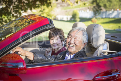 Happy Chinese Couple Enjoying An Afternoon Drive in Their Conver