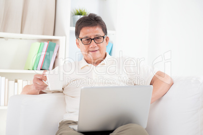 Mature Asian man surfing internet