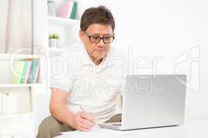 Mature Asian man using computer