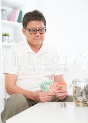 Mature Asian man counting money