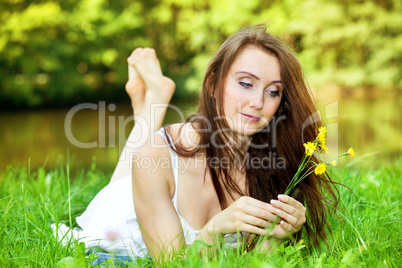 Woman with small bouquet of flowers lying in the park