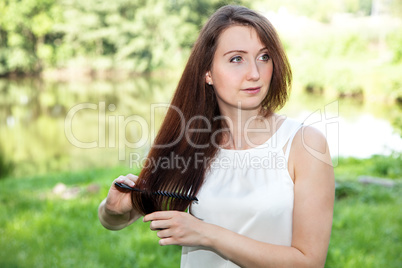 Woman in the park combing her long hair