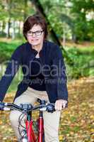 Woman riding a bicycle in autumn park