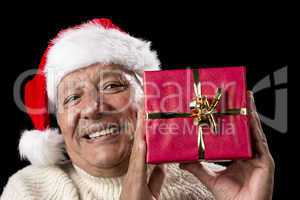 Smiling Old Man With Red Wrapped Christmas Gift