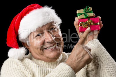 Smiling Senior Pointing At Two Wrapped Xmas Gifts