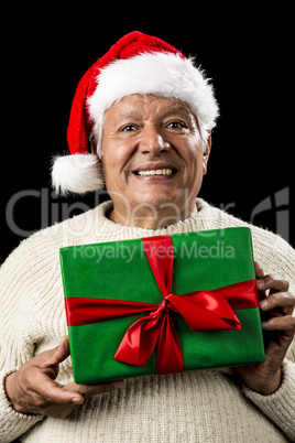 Male Senior With Santa Claus Cap and Green Gift