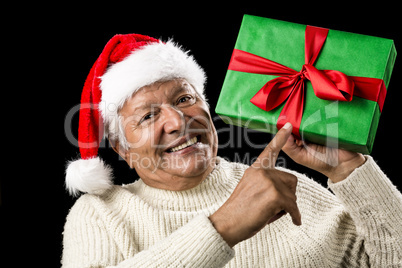 Old Man With Gentle Smile Pointing At Green Gift