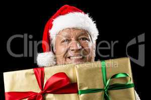Smiling Aged Man Peeking Across Two Golden Gifts
