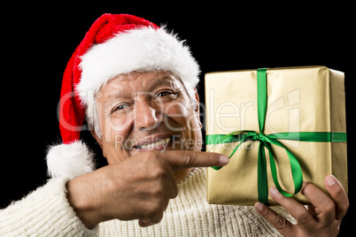 Broadly Grinning Aged Male Pointing At Golden Gift