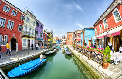 BURANO, ITALY - APRIL 8, 2014: Tourists enjoy colourful city bui