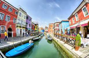 BURANO, ITALY - APRIL 8, 2014: Tourists enjoy colourful city bui