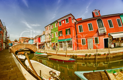 BURANO, ITALY - APRIL 8, 2014: Tourists enjoy colourful city bui