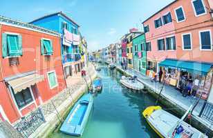 BURANO, ITALY - APRIL 8, 2014: Tourists enjoy colourful city bui