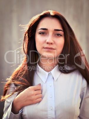 Portrait of a young pretty girl in a light shirt and with her ha