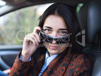 Young pretty  girl sitting behind the wheel of a car