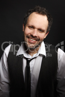 Attractive man with dark jacket smiles into the camera