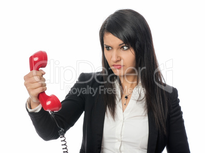 Frau schaut böse auf den Telefonhörer