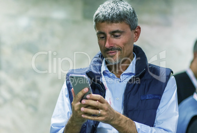 Caucasian man in the 40s enjoying his new smartphone indoor