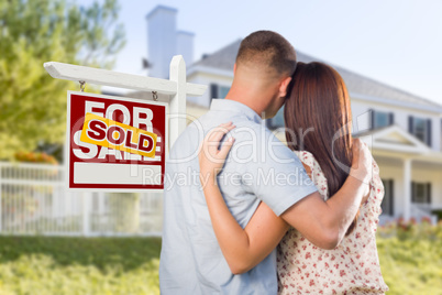 Sold For Sale Sign with Military Couple Looking at House