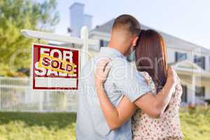 Sold For Sale Sign with Military Couple Looking at House