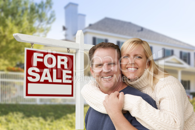 Couple in Front of New House and Real Estate Sign