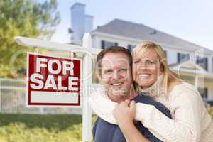 Couple in Front of New House and Real Estate Sign