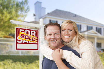 Couple in Front of New House and Sold Sign