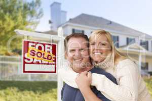 Couple in Front of New House and Sold Sign