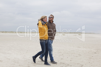 Couple goes on a sandy beach in autumn