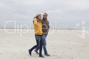 Couple goes on a sandy beach in autumn