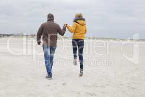 Couple on the sandy beach in autumn