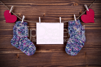 Baby Socks on a Line with Hearts and an Banner with Copy Space