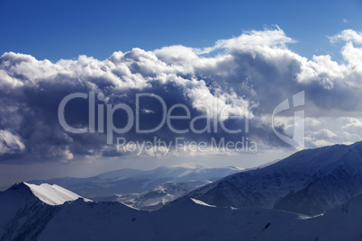 Winter mountains in evening and sunlight clouds