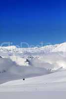 Winter snowy mountains and ski slope at nice day