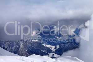 Top view on winter snowy mountains in clouds