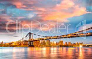 Amazing sunset view of Manhattan Bridge with East River reflecti
