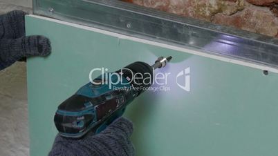 Repairer Make Install Drywall using Screwdriver and Screw, closeup