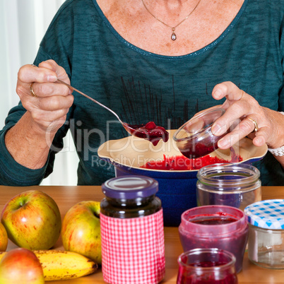 Senior woman filling homemade jam in the glass