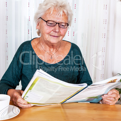 Elderly woman reading a magazine