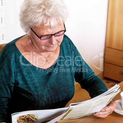 Elderly woman reading a magazine