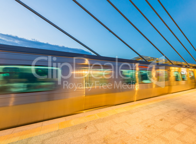 Train speeding up on a station at night. Blurred motion effect
