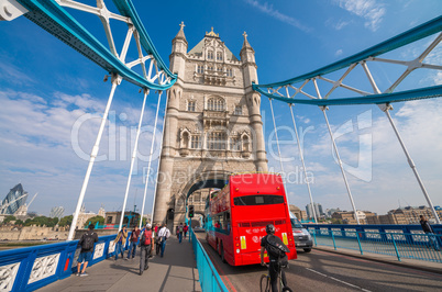 Red bus crossing Tower Bridge on a beautiful summer day - London